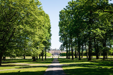 View over Drottningholm Palace from an alley in the park on a sunny summer day. Home residence of Swedish royal family. Famous landmark in Stockholm, Sweden