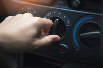 Woman hand is adjusting car air conditioning