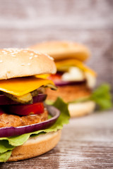 Close up of Delicious home made burgers on wooden plate. Fast food. Unhealthy snack