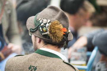 Mann in Tracht mit bayrischem Filzhut mit Gamsbart und Ansteckern von hinten