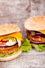 Delicious fresh home made burgers on wooden plate. Fast food. Unhealthy snack