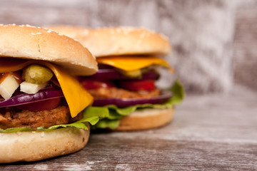 Delicious fresh home made burgers on wooden plate. Fast food. Unhealthy snack