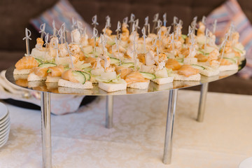 Canape with salmon and cucumber on skewers with cheese
