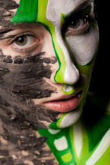 Close up portrait of model with extreme artistic make up on black background in studio photo. On stage beauty image. Conceptual make-up
