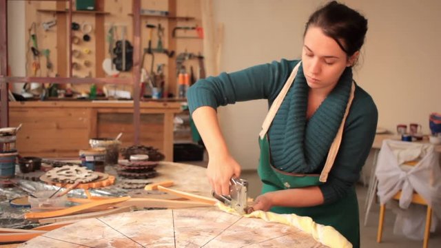 Girl fixing fabric on wooden circle