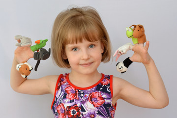  child, kid,(little girl) playing with dolls is wearing on the fingers.