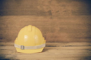 yellow construction safety helmet on wood.