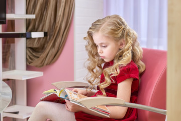 Little girl reading magazine. Child in a hairdressing salon. Reasons why children should read.