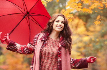 season and people concept - beautiful happy young woman walking in autumn park