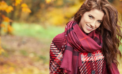 season and people concept - beautiful happy young woman walking in autumn park