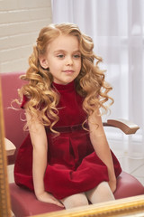 Little girl with beautiful hair. Caucasian child sitting indoor. Special occasion hairstyles for kids.