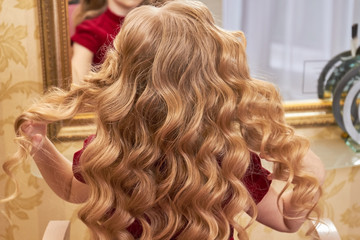 Beautiful hair of little girl. Wavy blonde hair. Golden rules of hair care.