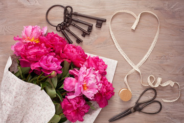 Ribbon in form of heart with bouquet of peonies. Concept of love, celebration, wedding, saint valentine's day. Top view