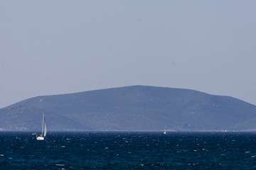 Obraz premium White sailboat on the blue aegean turkish sea