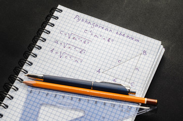 Page with formulas and the Pythagorean theorem with pen and pencil