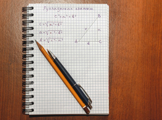 Page with formulas and the Pythagorean theorem with pen and pencil