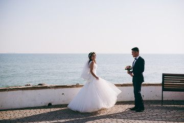 Plakat Wedding couple on a walk on the embankment near the sea