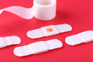 Medical plasters on red background