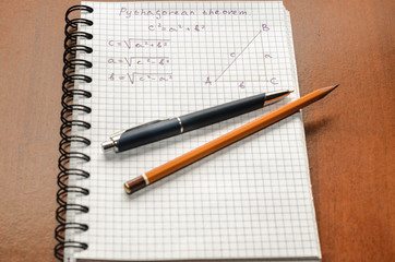 Page with formulas and the Pythagorean theorem with pen and pencil