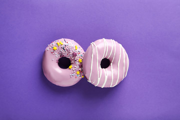 Tasty donuts with sprinkles on paper background