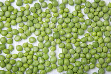 Fresh green peas on white wooden table