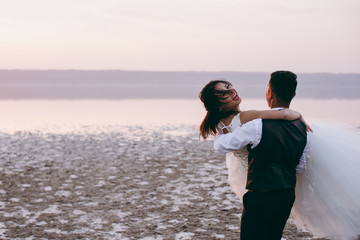 Wedding couple walking along the shore of the estuary