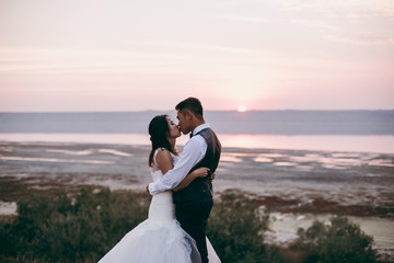 Wedding couple walking along the shore of the estuary