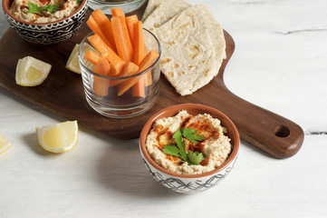 Homemade hummus with pita, carrot and cucumber sticks