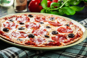 Pizza pepperoni with olives served
