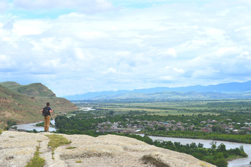 Backpacker in Uplistsikhe caves and rocks panorama