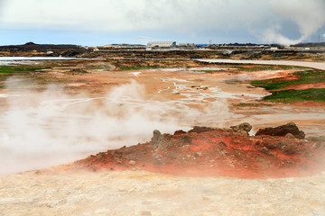 Colorful geothermal area Gunnuhver, with steam vents and a geothermal powerplant, in Iceland