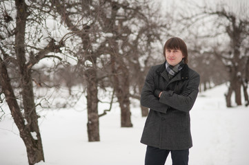 Handsome man walking in a snowy park