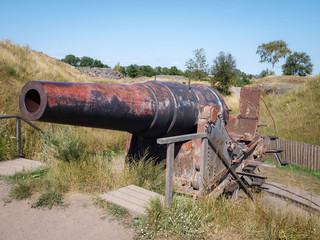 Rusty iron cannon installed on an fortress island next to Helsinki