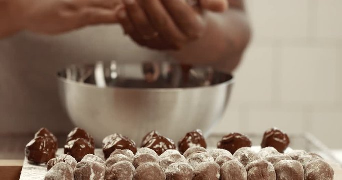 Chocolate master in his factory makes a truffles. Chocolate truffles making of process. Chocolate texture. Small business factory. Sunny chocolate factory