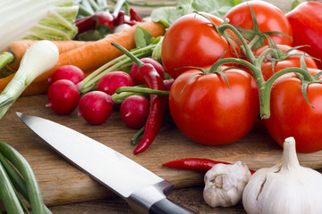 Fresh vegetables on kitchen board with knife 