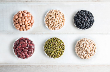 Mixed beans in bowl on wood background.