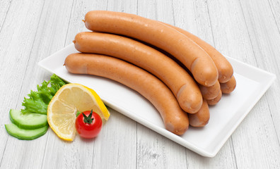 Wiener Würstchen - Produktfoto aus weißer Platte und Holzhintergrund