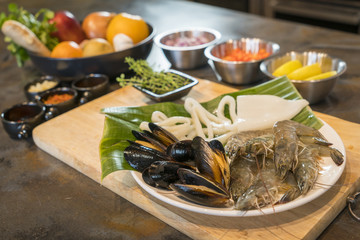 Raw seafood on plate with fruits and vegetables, healthy food, prawn, clam squid