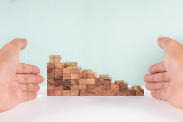Wooden block stacking as staircase level with golden coins on top, business growth concept