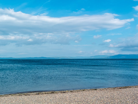 Peble beach blue sea hills and blue sky.