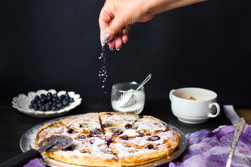 Female adding sugar to a sweet pie