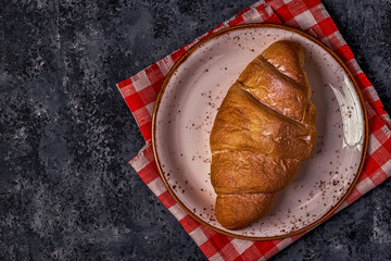 Fresh croissant on dark background.