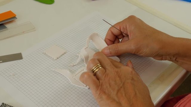 female artiest makes polymer clay buttons in her studio