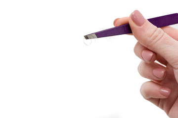Close up of woman's hand holding eyebrow tweezers isolated on white. Eyebrow Correction. Closeup Of Beautiful Young Woman hand with tweezers for Brows. Beauty Concept. Woman correcting eyebrows form