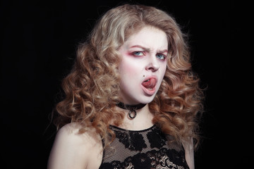 Portrait of young girl bursts showing her tongue