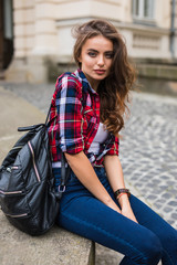 Fototapeta premium Young beauty woman posing in the street with backpack brunette hair outdoor closeup portrait