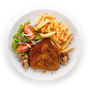Fried pork chop, French fries and vegetable salad on white background