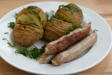 Potatoes with sausages on the grill with herbs
