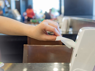 Woman is pulling tissue from box in resturant