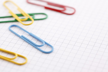 Colorful paper clips on graph paper with copy space